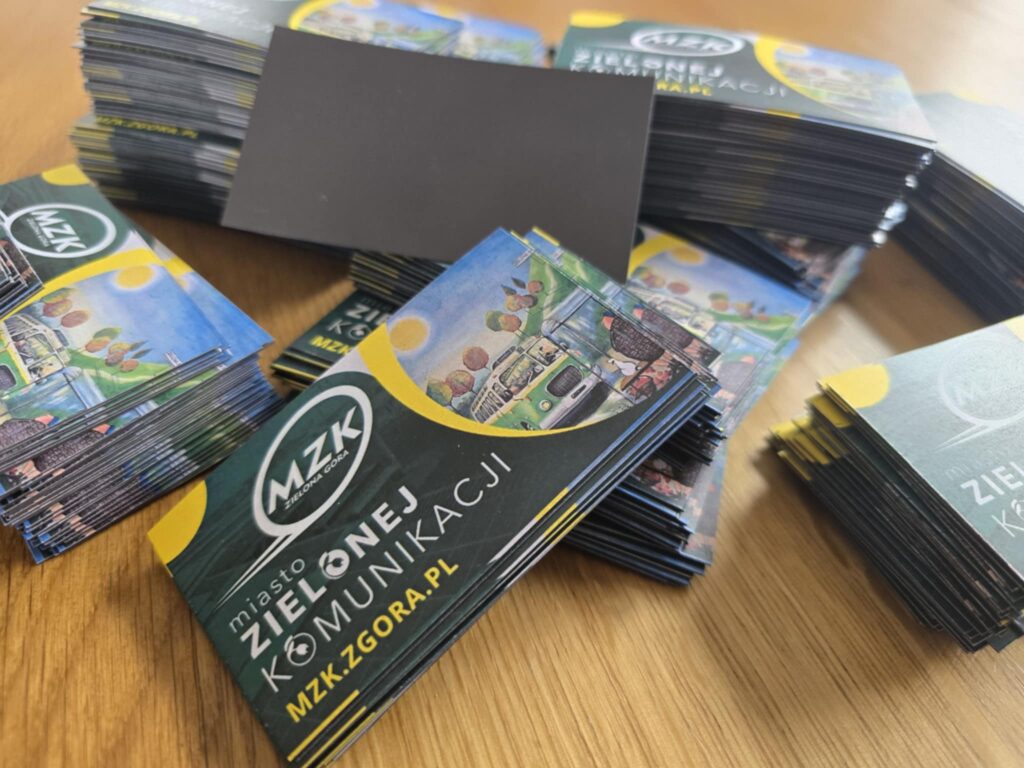 Stos kolorowych magnesów reklamowych 90x50mm dla MZK Zielona Góra, z logo i grafiką autobusu.