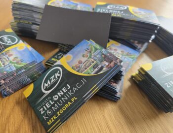Stos kolorowych magnesów reklamowych 90x50mm dla MZK Zielona Góra, z logo i grafiką autobusu.