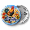 Przypinka Dożynki Kogut Folkowy: kolorowa przypinka na dożynki z napisem DOŻYNKI POWIATOWE – przód i aluminiowy tył z agrafką