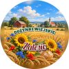 Wzór: Przypinka Dożynki Wiejskie – napis DOŻYNKI WIEJSKIE i pole wieś na pastelowym tle
